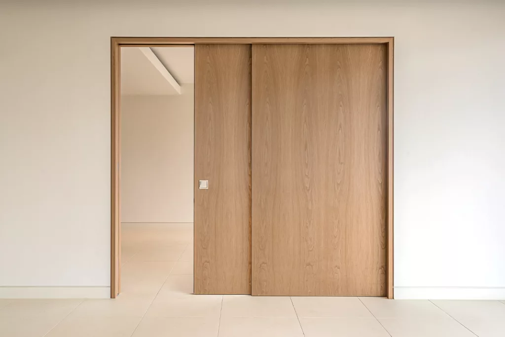 Stylish white Pocket Door seamlessly dividing the kitchen and dining area in a contemporary home.